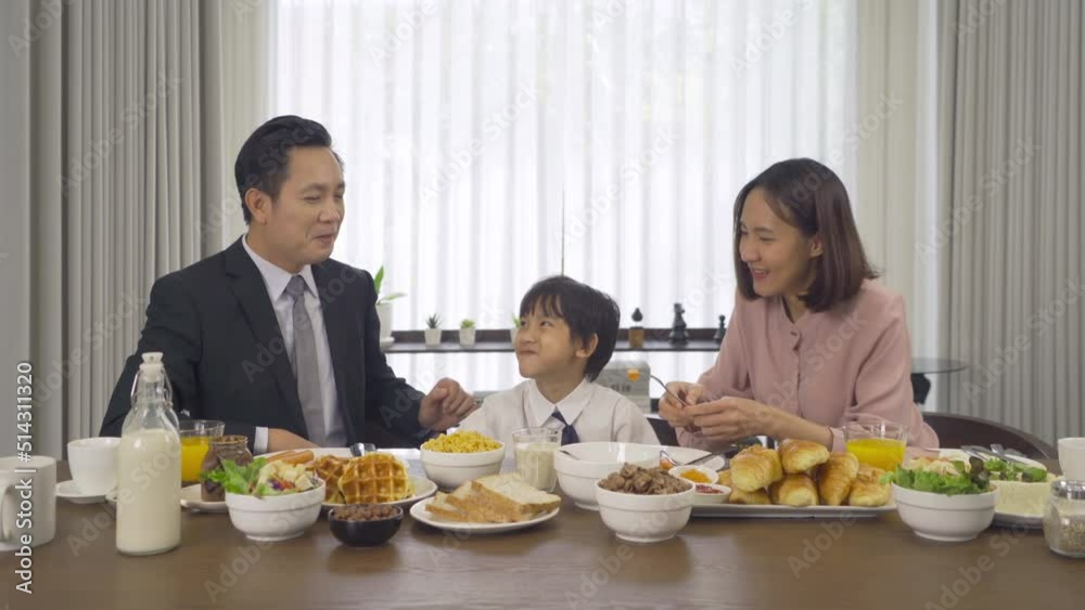 Portrait of happy smiling Asian Family eating breakfast food together before the child going to school at home. Family relationship. Love of father, mother, and son. People lifestyle. Business man. Portrait of happy smiling Asian Family eating breakfast food together before the child going to school at home. Family relationship. Love of father, mother, and son. People lifestyle. Business man.