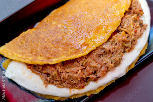 Cachapa with pulled meat, corn tortilla with cheese, meat and butter photo