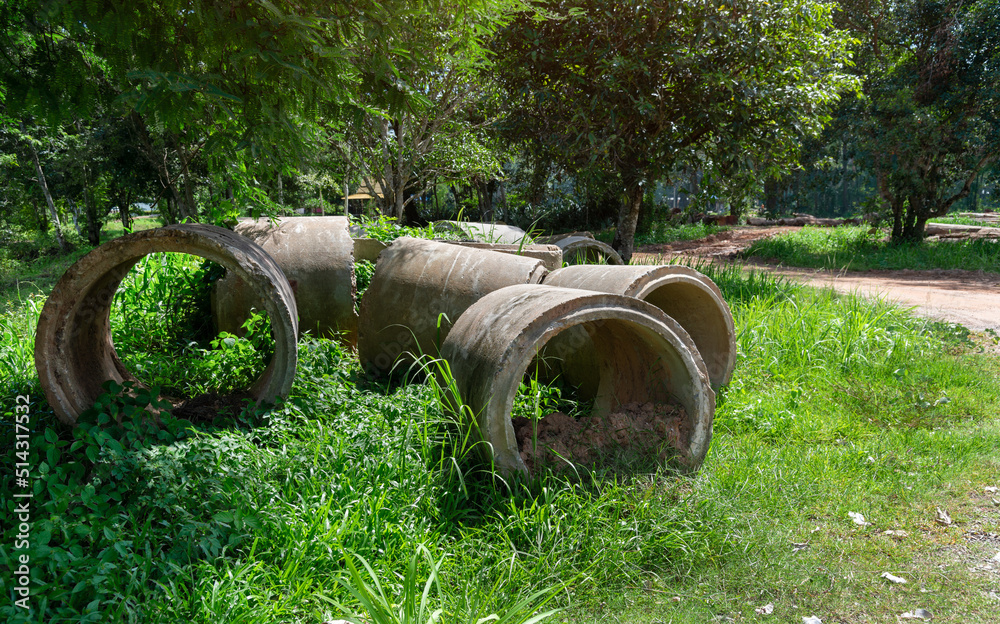 Old concrete pipes lying in the autumn grass. Old concrete pipes lying in the autumn grass.