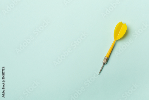 Yellow darts on color background, top view