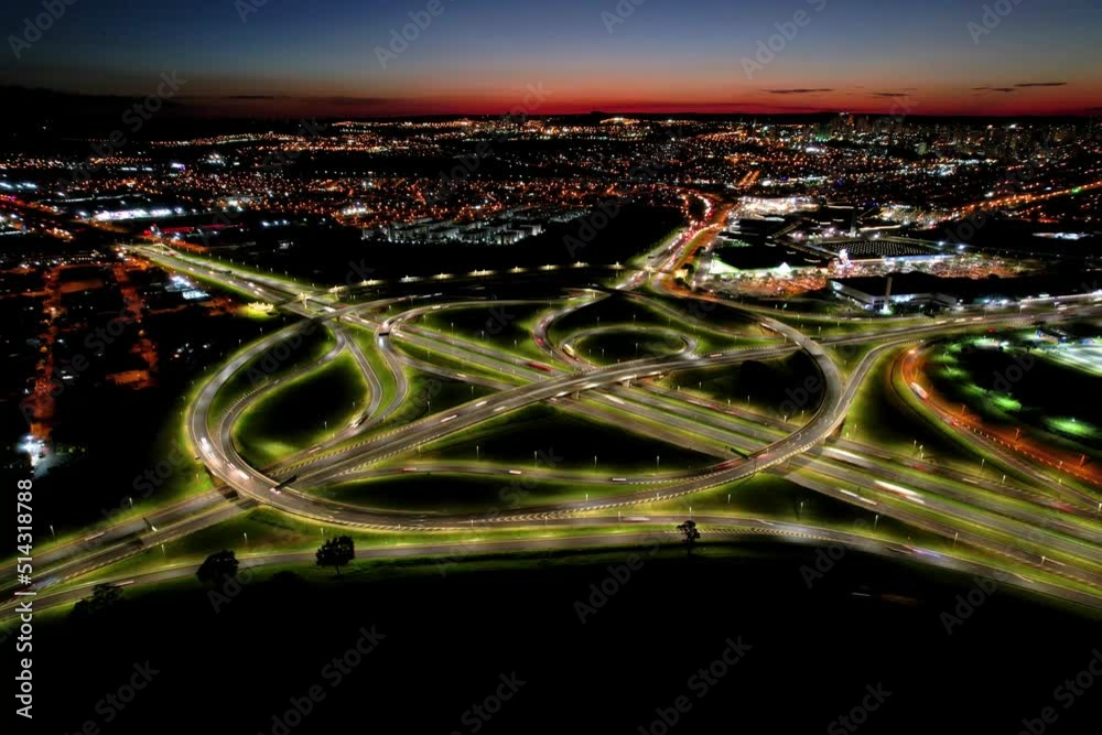 Car traffic at sunset in a busy city almost at night. Video made with drone in Timelapse