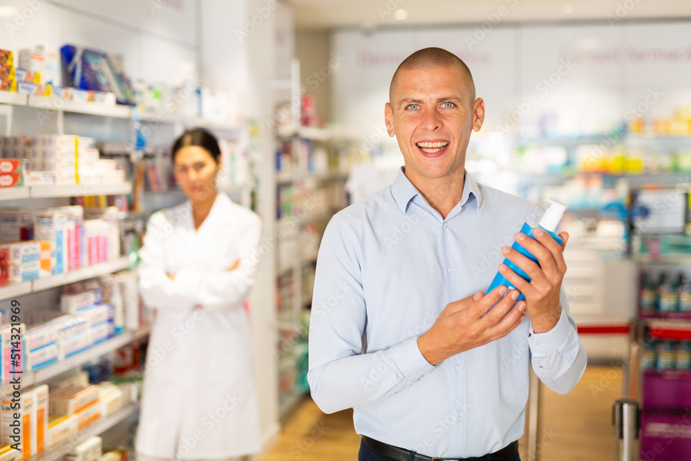 Male customer looking for products of body care in pharmacy