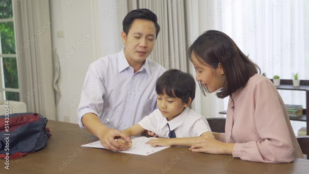 Portrait of happy smiling Asian Family. A student studying homework from school at home or house in family relationship. Love of father, mother, and son. People lifestyle. Education activity. Portrait of happy smiling Asian Family. A student studying homework from school at home or house in family relationship. Love of father, mother, and son. People lifestyle. Education activity.