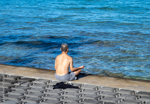 Person Meditating on the the Edge of the Sea.