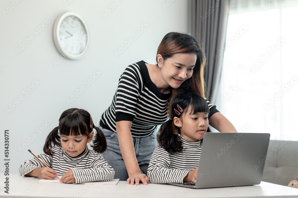 Asian little young girl kid learning online class at home with mother ...