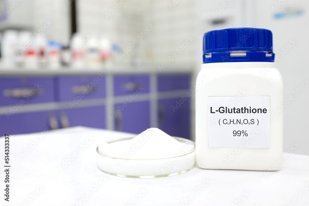 Selective focus of a bottle of pure glutathione chemical compound or l-glutathione whitening beside a petri dish with powder. White Chemistry laboratory background with copy space. Selective focus of a bottle of pure glutathione chemical compound or l-glutathione whitening beside a petri dish with powder. White Chemistry laboratory background with copy space.