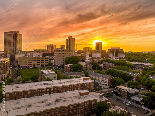 Aerial view of downtown New Brunswick, New Jersey with dramatic colorful sunset sky low rise apartment buildings and first reformed church, high rise office buildings, parking lots photo