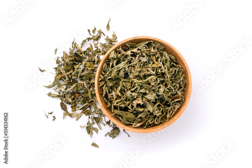Dry stevia rebaudiana Bertoni in wooden bowl , sweet leaf sugar substitute isolated on white background , top view , flat lay.