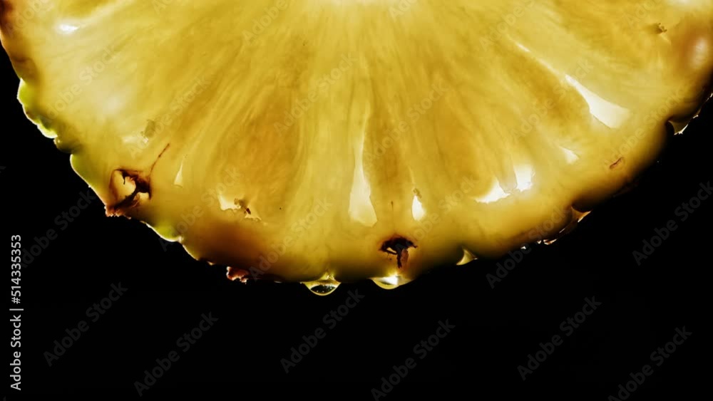Juicy pineapple slice on black background. Fruit ananas close-up texture, healthy sweet food. Summer refreshment concept.