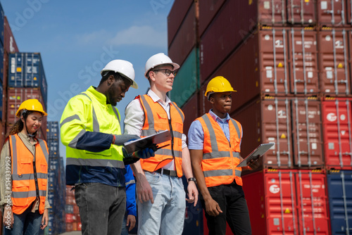 Group of engineer worker and manager standing in the shipping yard container.