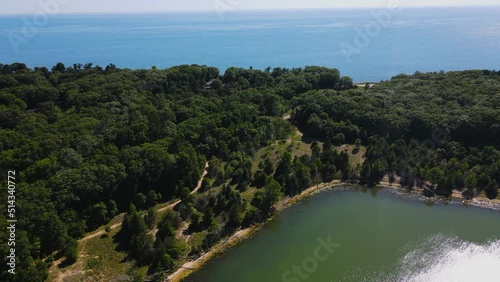 Forward motion over lush trees to show lake Michigan. photo