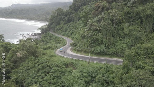 Aerial view of road in beautiful green forest and sea coast, Colorful landscape with cars on roadway, blue water, trees in summer. Shot on D-Log Flat Profie photo