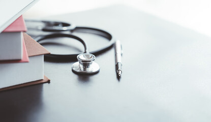 Medical student textbooks with pen and stethoscope on table. medical education medicine books and notes on the table.