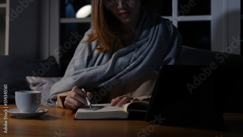 Asian businesswoman or freelancer working hard at the night looking the laptop digital tablet and document in workplace at late overtime deadline, Stressed busy and exhausted of work at home.