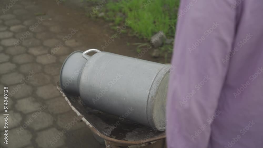 Worker carrying buckets of milk and walking in rural. Milkmaid. Dairy products Worker carrying buckets of milk and walking in rural. Milkmaid. Dairy products