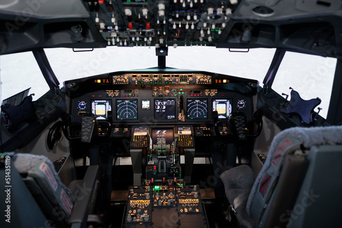Nobody in empty captain cabin with dashboard navigation and engine throttle to fly airplane and travel. Cockpit with control panel command and power buttons, radar compass and windscreen.