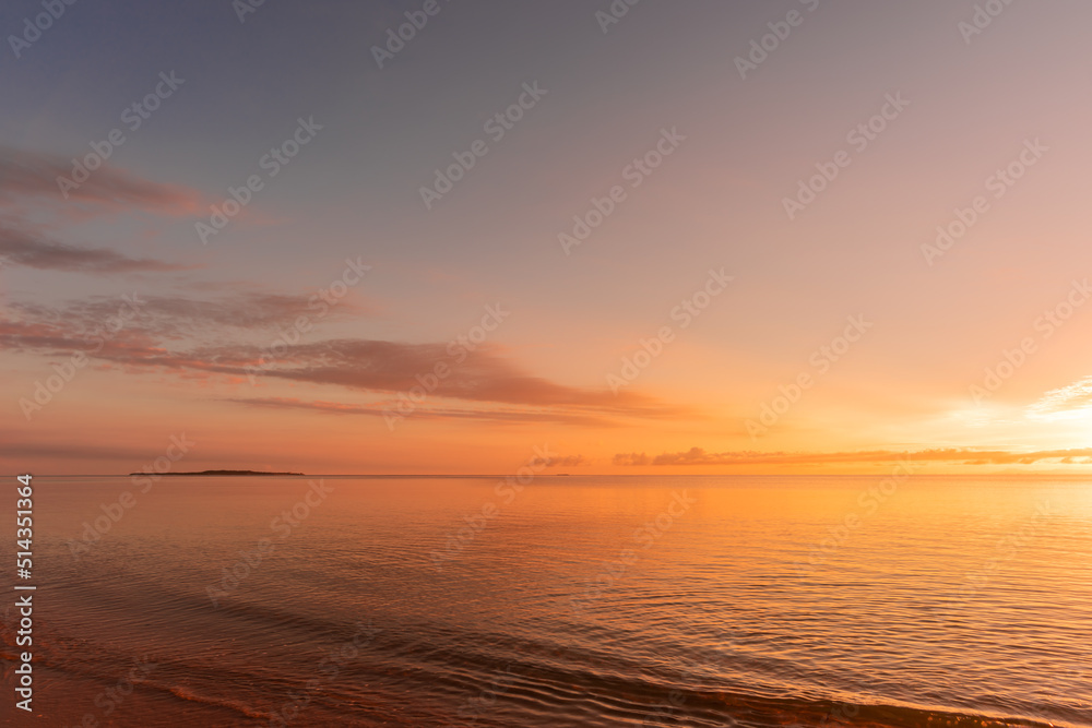 Soft wave of morning ocean on sandy beach. Tranquil sunrise concept.
