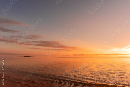 Soft wave of morning ocean on sandy beach. Tranquil sunrise concept.