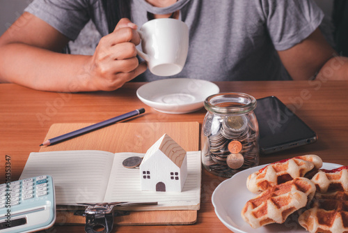 A woman picking up a coffee cup on her desk full of things.Hard work concept.