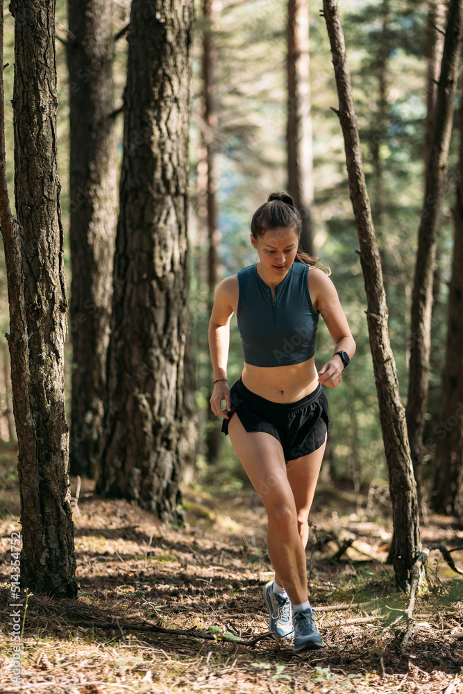 Young woman in sportswear enjoy trail running and working out in the forest Young woman in sportswear enjoy trail running and working out in the forest