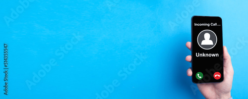 Fotografie Man showing mobile phone with incoming call from unknown caller.