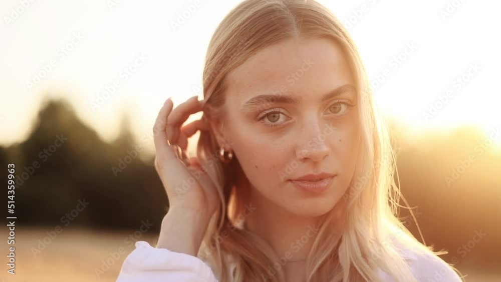 Portrait of beautiful blond woman with long hair. Sunny face of gorgeous girl looking to camera.