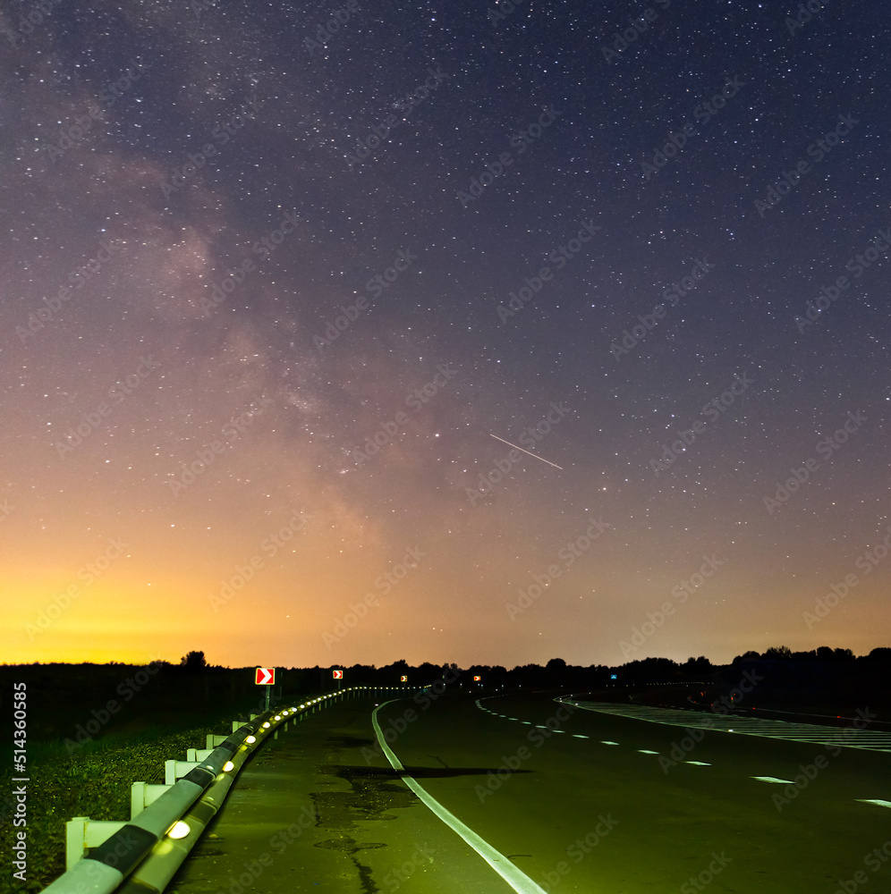 asphalt road turn  under dark starry sky with milky way, night transportation infrastructure scene