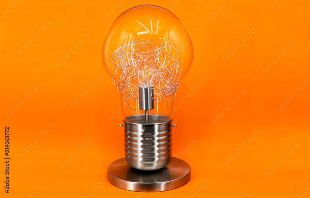Żarówka - lampa w kształcie żarówki na pomarańczowym tle - obrazy, fototapety, plakaty 