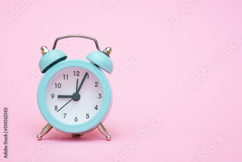 Blue alarm clock on a pink background. Copy space. Close-up. Deadline concept