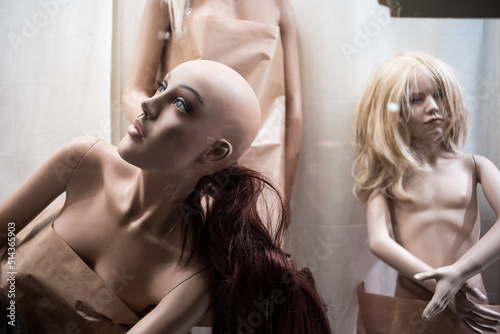 Plastic dummy model mannequin behind a store shop glass photo