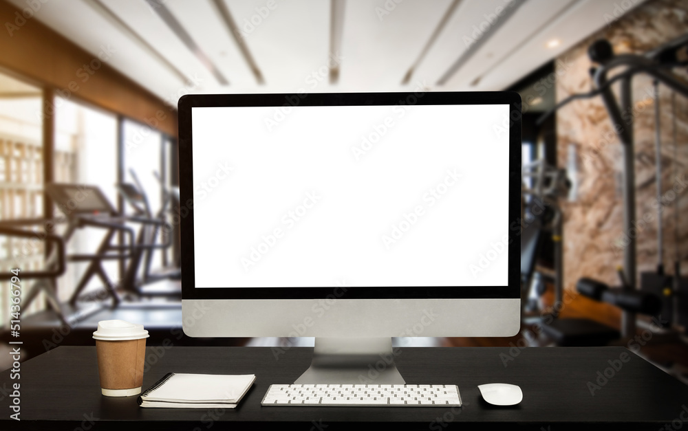 Fototapeta premium Computer Monitor, Keyboard, coffee cup and Mouse with Blank or White Screen Isolated is on the work table at the fitness gym