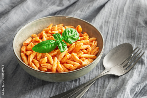 Close up cavatelli pasta in tomato sauce on the tablecloth photo