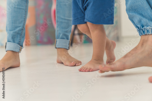 parents teaching baby to walk at home, closeup family concept. High quality photo