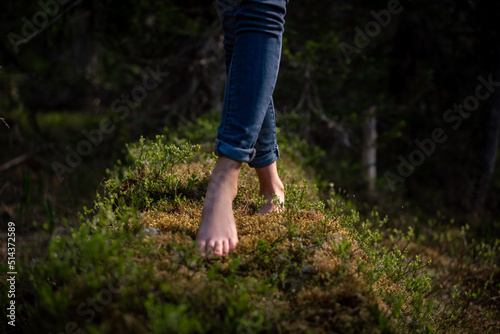 Close-up of bare feet on moss in forest © horimono
