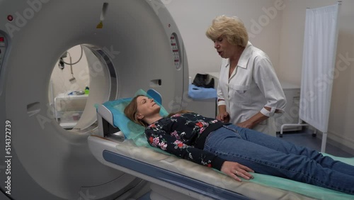 Young female patient lying on a ct or mri scan bed during medical exam photo