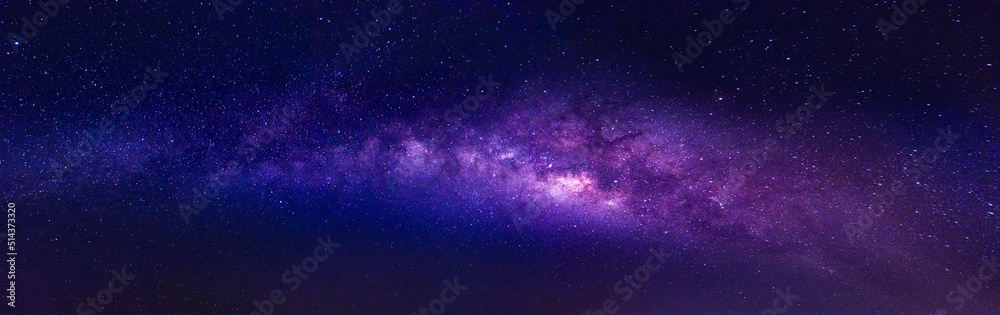 Milky way in the night sky and stars on dark background with noise and grain. Photo taken with long exposure and white balance selected.