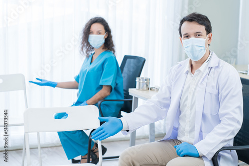 Portrait of Caucasian doctor and nurse sitting with smile in clinic. 