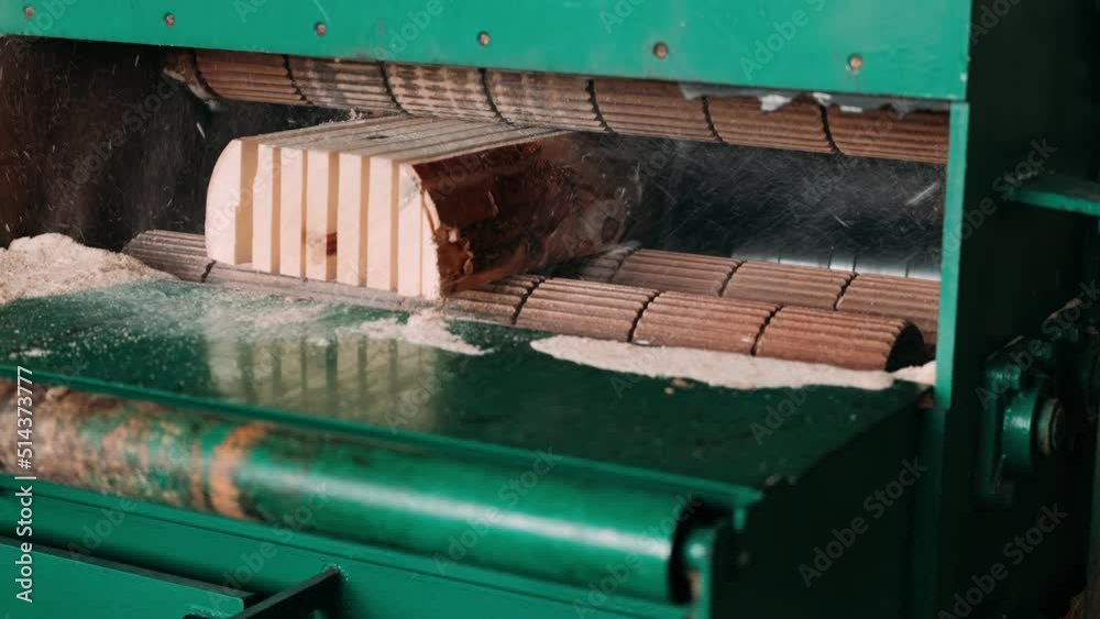Cutting wood at a wood factory. Sawmill machine saws the tree trunk on the plank boards. Close up of sawing wood. Carpentry. Wood Production. Cutting wood at a wood factory. Sawmill machine saws the tree trunk on the plank boards. Close up of sawing wood. Carpentry. Wood Production.