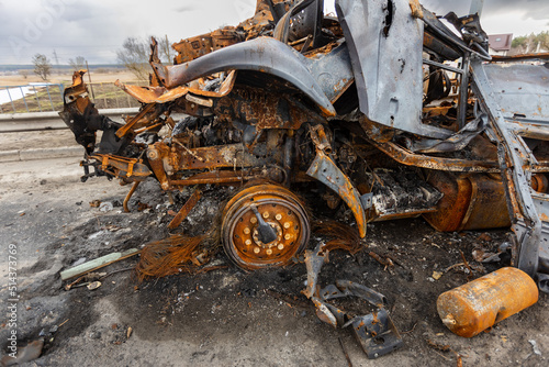 Hostomel, Kyev region Ukraine - 09.04.2022: Burnt military vehicles of Russian soldiers on the bridge across the river. Cars after being hit by rockets, mines. Rusty cars. Charred car parts.
