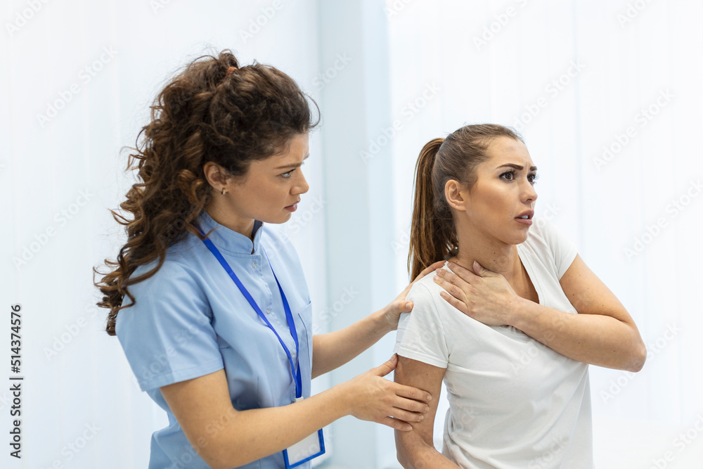Woman doctor osteopath in medical uniform fixing woman patients shoulder and back joints in manual therapy clinic during visit. Professional osteopath during work with patient concept Woman doctor osteopath in medical uniform fixing woman patients shoulder and back joints in manual therapy clinic during visit. Professional osteopath during work with patient concept