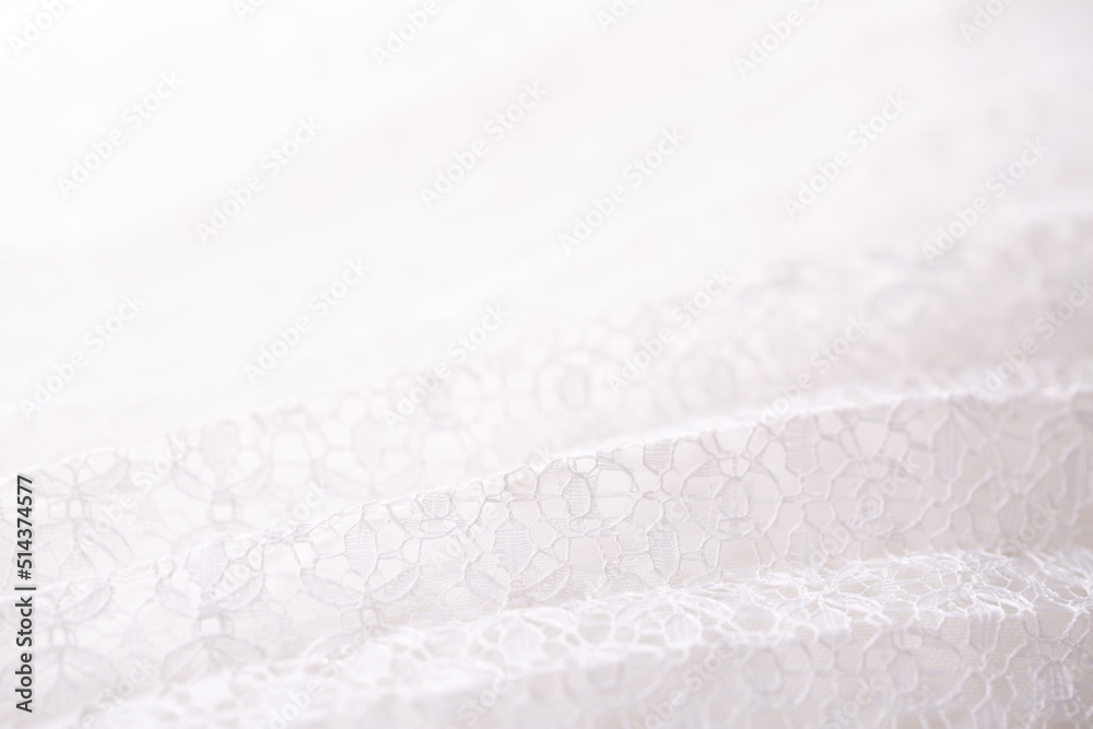 White fabric pleated with lace as a background. Lightweight summer clothing material, patterned texture. Wedding Dress.