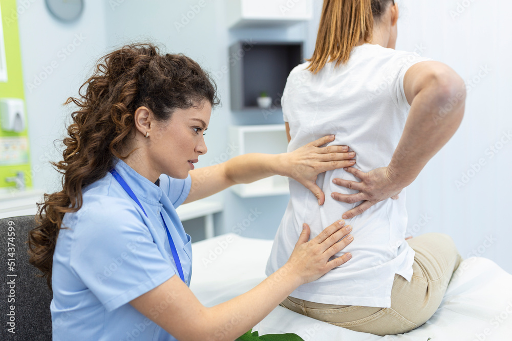 Obraz premium Physiotherapist doing healing treatment on womans back. Back pain patient, treatment, medical doctor, massage therapist.office syndrome