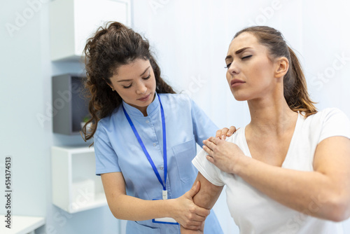 Woman doctor osteopath in medical uniform fixing woman patients shoulder and back joints in manual therapy clinic during visit. Professional osteopath during work with patient concept photo