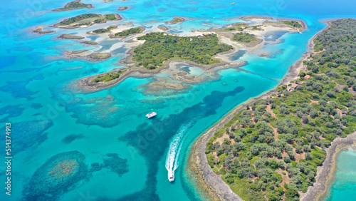 Aerial drone photo of tropical exotic volcanic island complex of Lihadonisia forming a blue lagoon and small islet of Monolia with turquoise clear organised beach, north Evia island, Greece