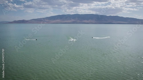 Three Jet Ski Riders on Sea Doos Speeding on Utah Lake Water Surface photo