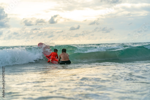 Photography Happy Asian family grandfather teaching grandchild boy surfing on surfboard in the sea on summer vacation