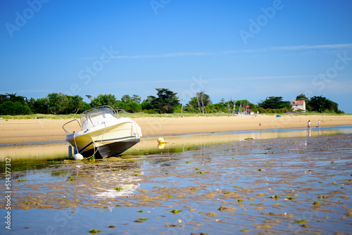 Murais de parede A motorboat laying on the beach at lowtide on a sunny summertime on the Isle of