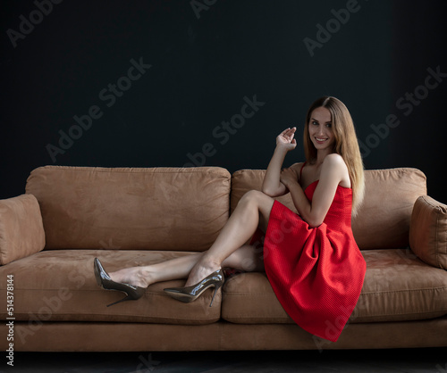 young beautiful woman sitting on a sofa near the window