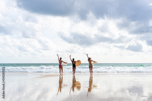Photography Group of Asian woman surfer in swimwear holding surfboard walking together on tropical beach at summer sunset