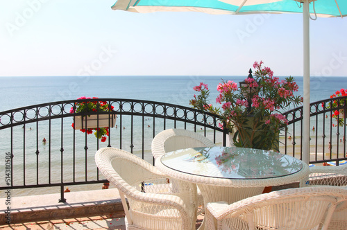 Cozy veranda next to the beach with wicker furniture and an umbrella. Nessebar  Bulgaria